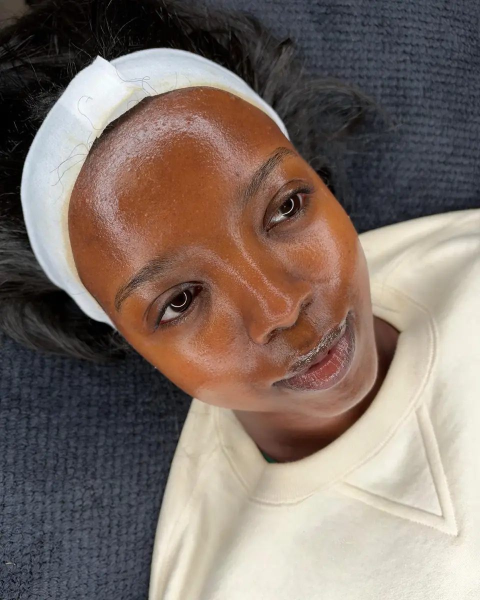 A client with a white headband lying back on the treatment couch at Glow By Yaz after a facial